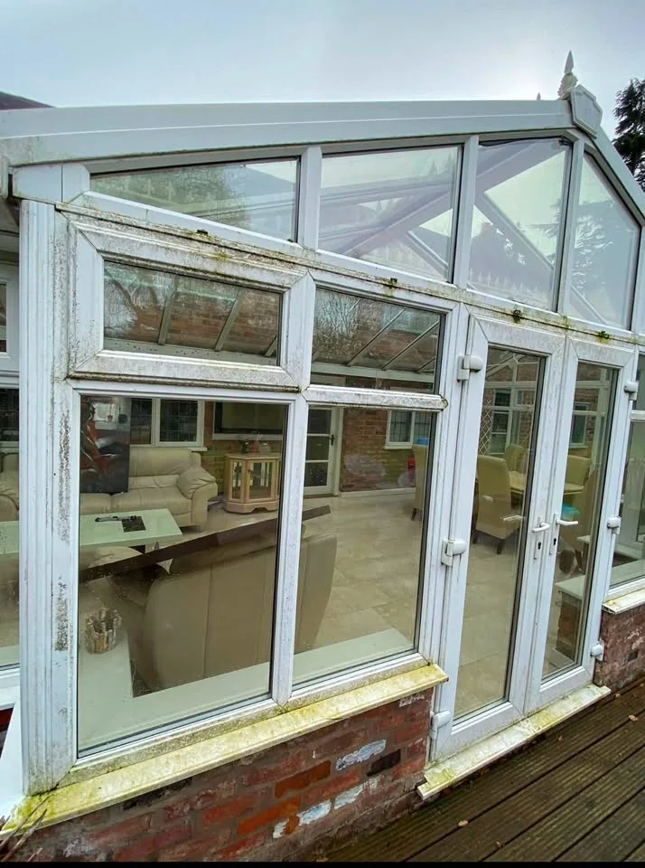 Conservatory before cleaning with green algae on the frames